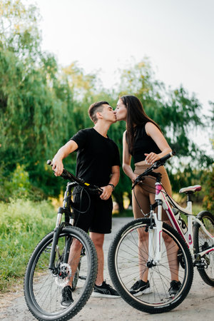 Young loving couple kissing on the bicyclesの写真素材
