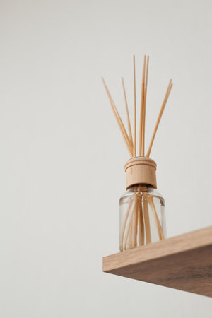 Aromatic reed air freshener on light indoors. Space for text