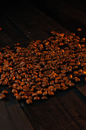 Warm photo of coffee beans on a black wooden backgroundの写真素材