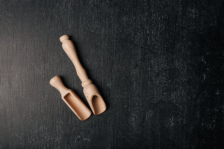Two wooden spoon a black background. Wooden kitchen accessoriesの写真素材