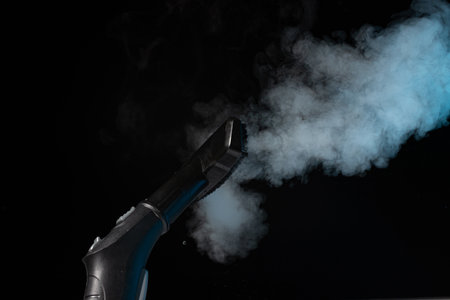 Steam cleaning with brush and steam on black backgroundの写真素材