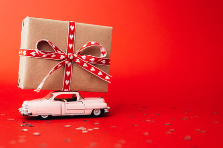 Delivery gift box on valentines day on red background.の写真素材