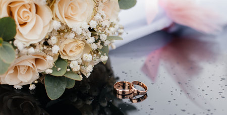 A beautiful toned picture with wedding rings lies on a black surface against the background of a...