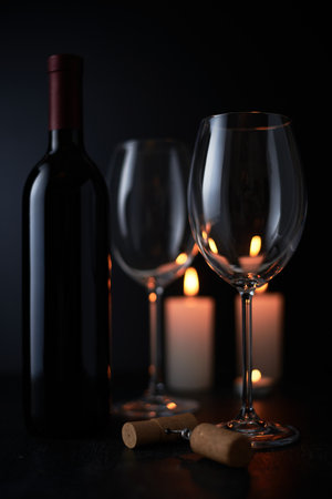 Elegant red wine glass and a wine bottle in black backgroundの写真素材