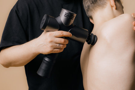 Electric massager gun in hand massages your muscles. Sport recovery concept