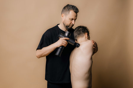 Electric massager gun in hand massages your muscles. Sport recovery conceptの写真素材