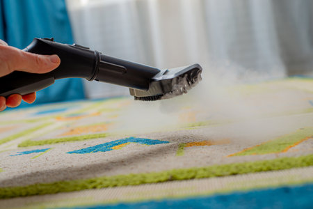 cleaning carpet in childrens room with steamの写真素材