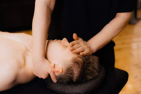 Young man receiving massage at spa salonの写真素材