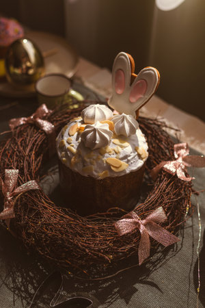 Easter decoration of colorful eggs in a basket and a rabbit on the kitchen table in a rustic style....