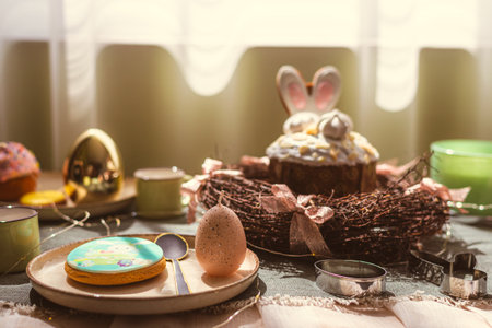 Easter decoration of colorful eggs in a basket and a rabbit on the kitchen table in a rustic style....