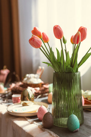 Easter decoration of colorful eggs in a basket and a rabbit on the kitchen table in a rustic style....