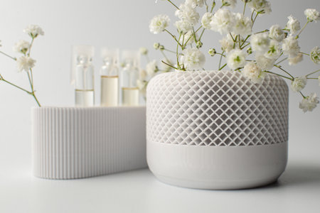 A small artificial plant with vibrant green leaves sits in a textured white pot against a clean white backgroundの写真素材