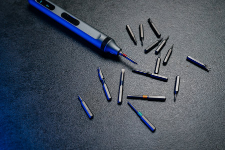 Electric mini screwdriver and several different interchangeable bits.の写真素材