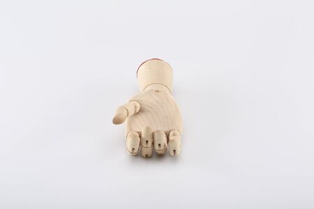 Wooden hand turned up on a gray backgroundの写真素材