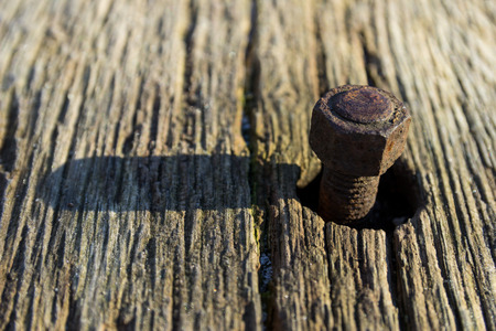 A rusty bolt in an old wooden plankの写真素材