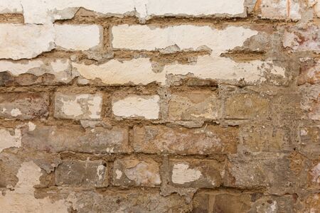Rough brick wall with white paint coming looseの写真素材