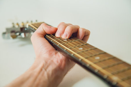 man musician hand holding classic wooden guitar neck. Old female guitarist put fingers on acoustic...