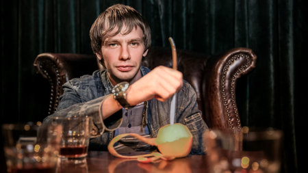 Young hungry crazy man holding a fork and a knife. Isolated on black background.