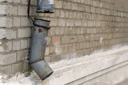 broken downpipe against a brick wallの写真素材