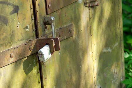 old green spotted wall barn padlockedの写真素材