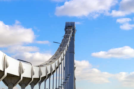 Part of the support of a gray metal bridge against a cloudy skyの写真素材