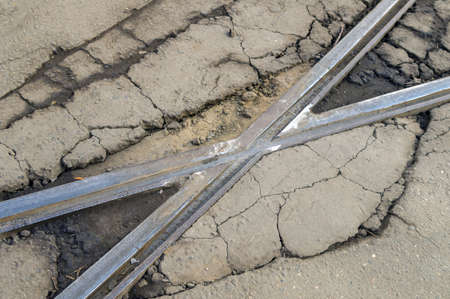 The intersection of tram tracks is criss-crossed. Broken asphalt. Desolation.