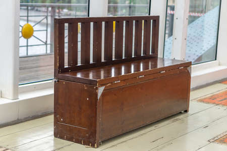 A wooden bench with a closing tender part, like a chest on a wooden floorの写真素材