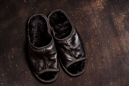 Homemade slippers made of leather with fur inside. Protecting the feet from the cold in the house when there is no heating.の写真素材