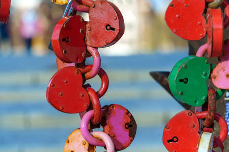 Multi-colored metal locks in the shape of a heart. Fastened in the form of a chain.の写真素材