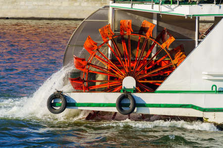 The pushing wheel of an old river ship is in motion. Red.の写真素材