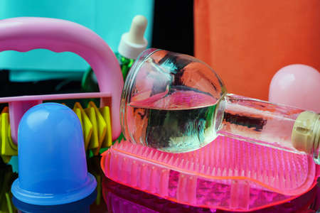 Means for massage. Oil, silicone cans, mitten, tehanic massager. On a dark mirror surface.