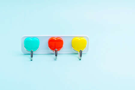 Towel hooks in the shape of hearts of different colors. Three pieces on one bar.の写真素材