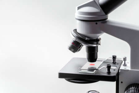 Cocept blood investigation. Microscope with a bright red drop on the slide.