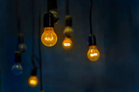 Old incandescent bulbs with a bright spiral in a dark room.の写真素材