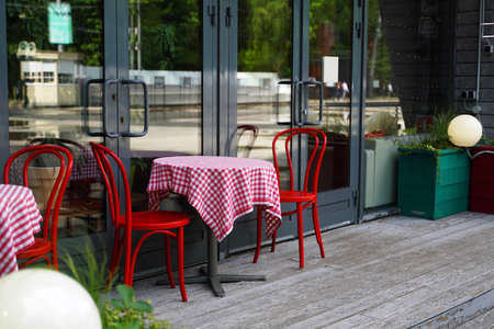Outdoor cafe red chairs and table with red and white tableclothの写真素材