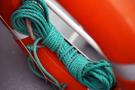 A green rope is wound and tied to a lifebuoy.の写真素材