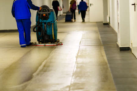 A worker at the airport washes the floor with a special machineの写真素材