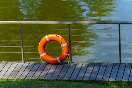 A lifebuoy made of plastic stands near the fence of the reservoirの写真素材