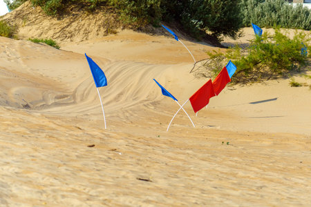 Red and blue flags to limit the race track to the sandの写真素材