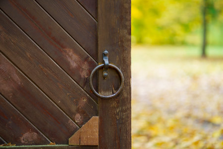 Wooden gate with handle in the shape of a ring of metalの写真素材