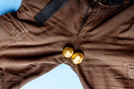 The concept of muscularity. Men's pants with two gold nutsの写真素材