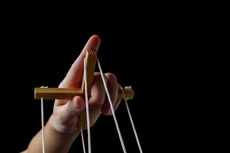 The concept of manipulation. Hand holds a vaga with ropes to control the puppetの写真素材