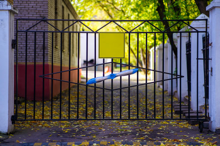 Metal gate with aircraft propeller and yellow sign for inscription
