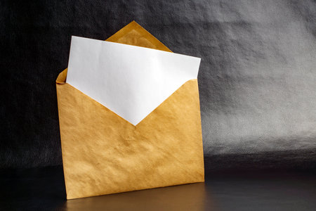 A sheet of paper in a vintage paper envelope on a dark backgroundの写真素材