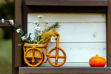 A bicycle with a basket of gossip made of grass and wood stems for decoration. Near by pumpkinの写真素材