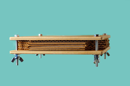Botanical press made of wood for drying plants on a blue background