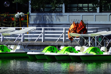 A number of catamarans stand at the pier on the pond for rentの写真素材