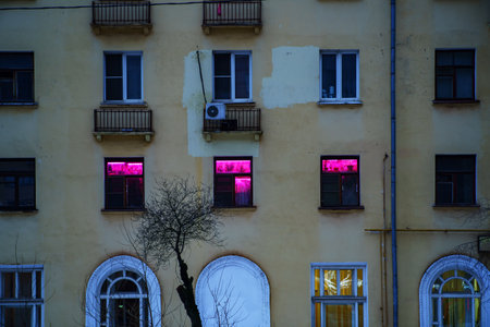 Building with windows illuminated with purple light for plantsの写真素材