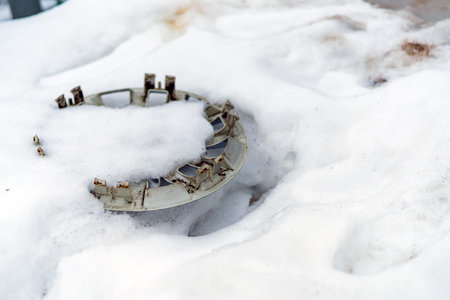 The lost cap from the wheel of the car lies in the snowの写真素材