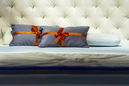 Pillows with gift ribbon on a new bedの写真素材